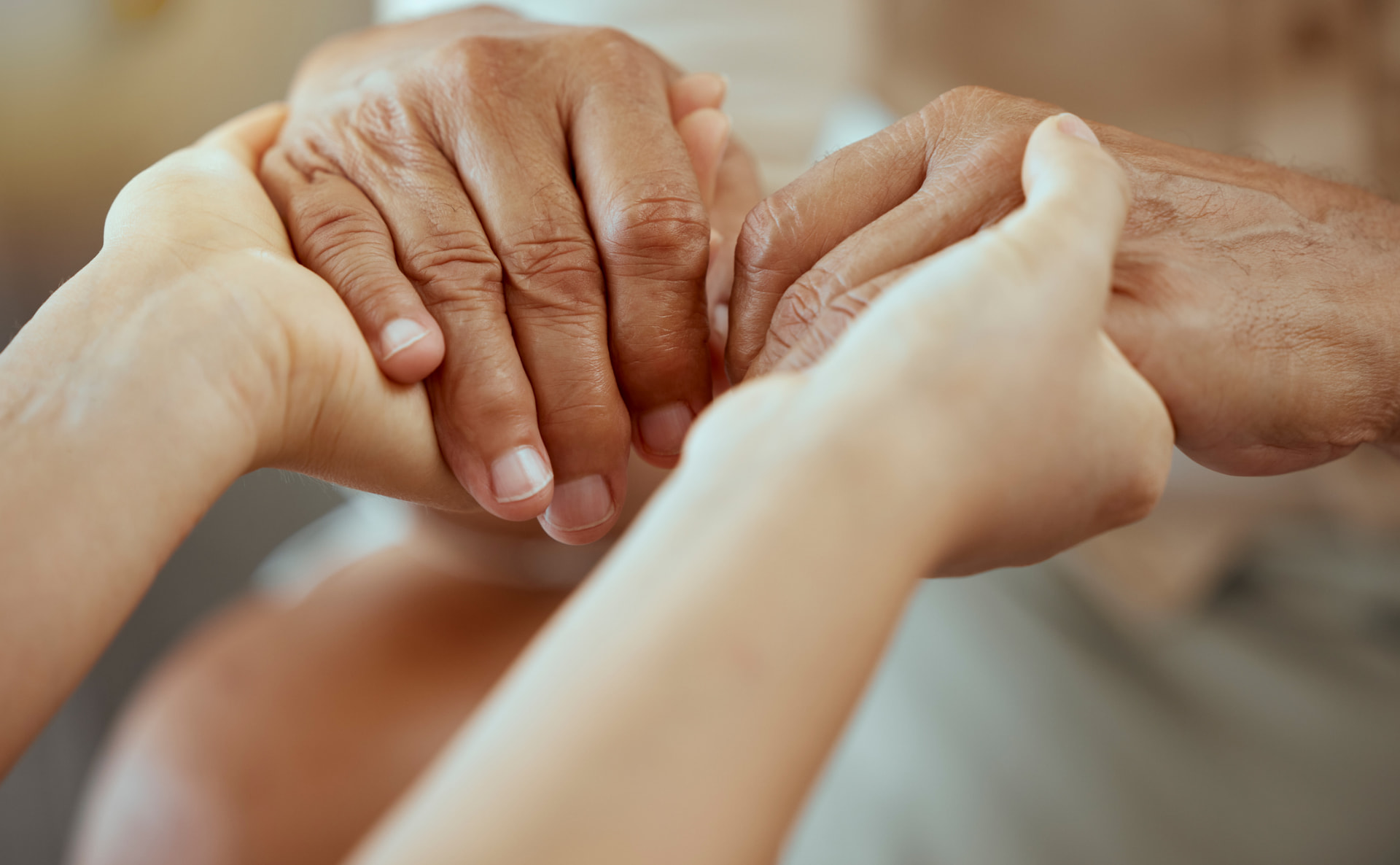 Dos manos sosteniendo con cariño la mano de una persona mayor